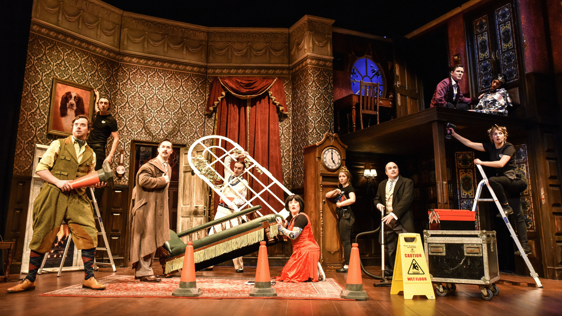 The Play That Goes Wrong Production Shot: A wide shot of the main cast looking at the audience with shocked faces.