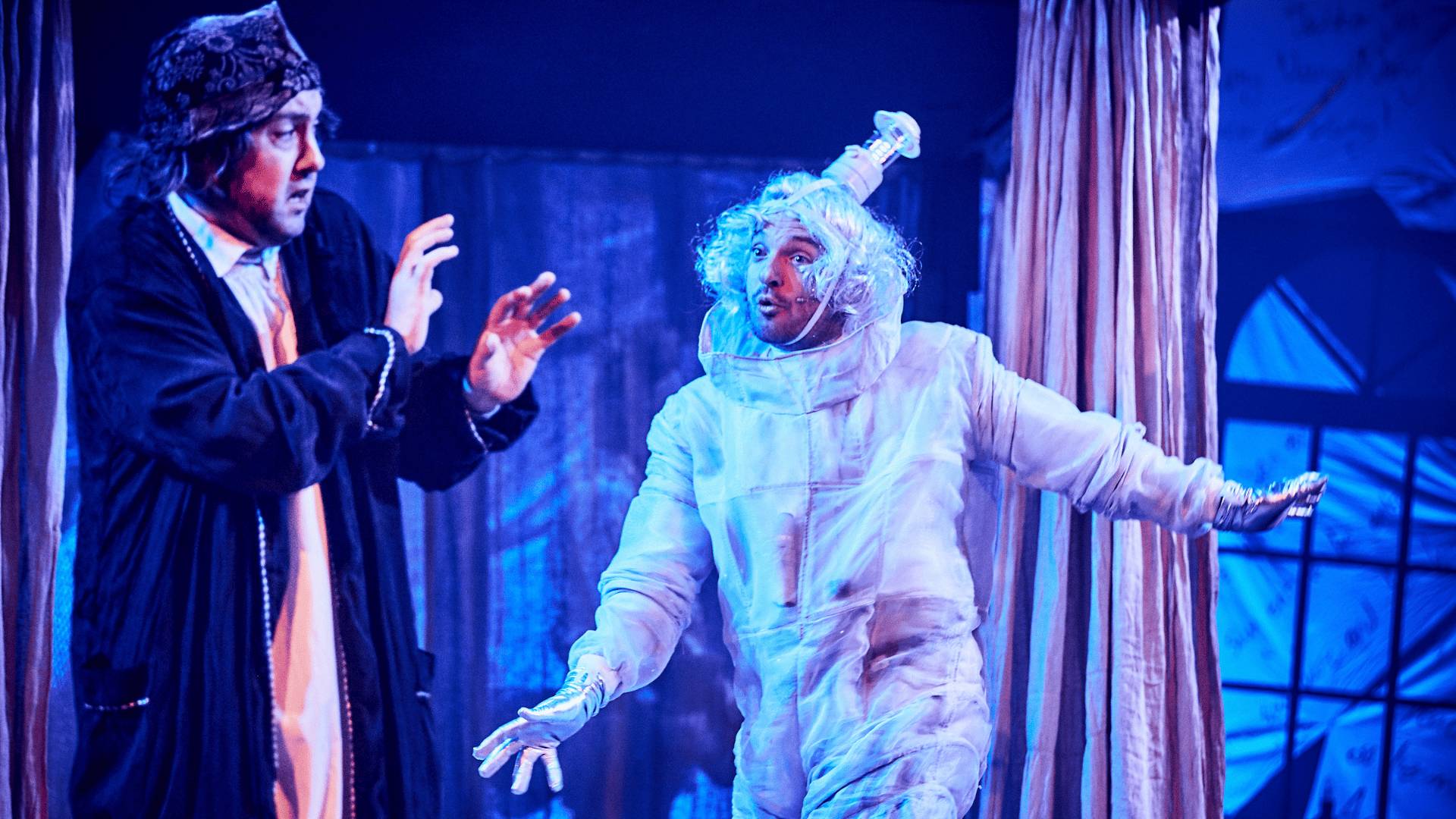 A Christmas Carol production shot: Scrooge looks scared of one of the Christmas ghosts