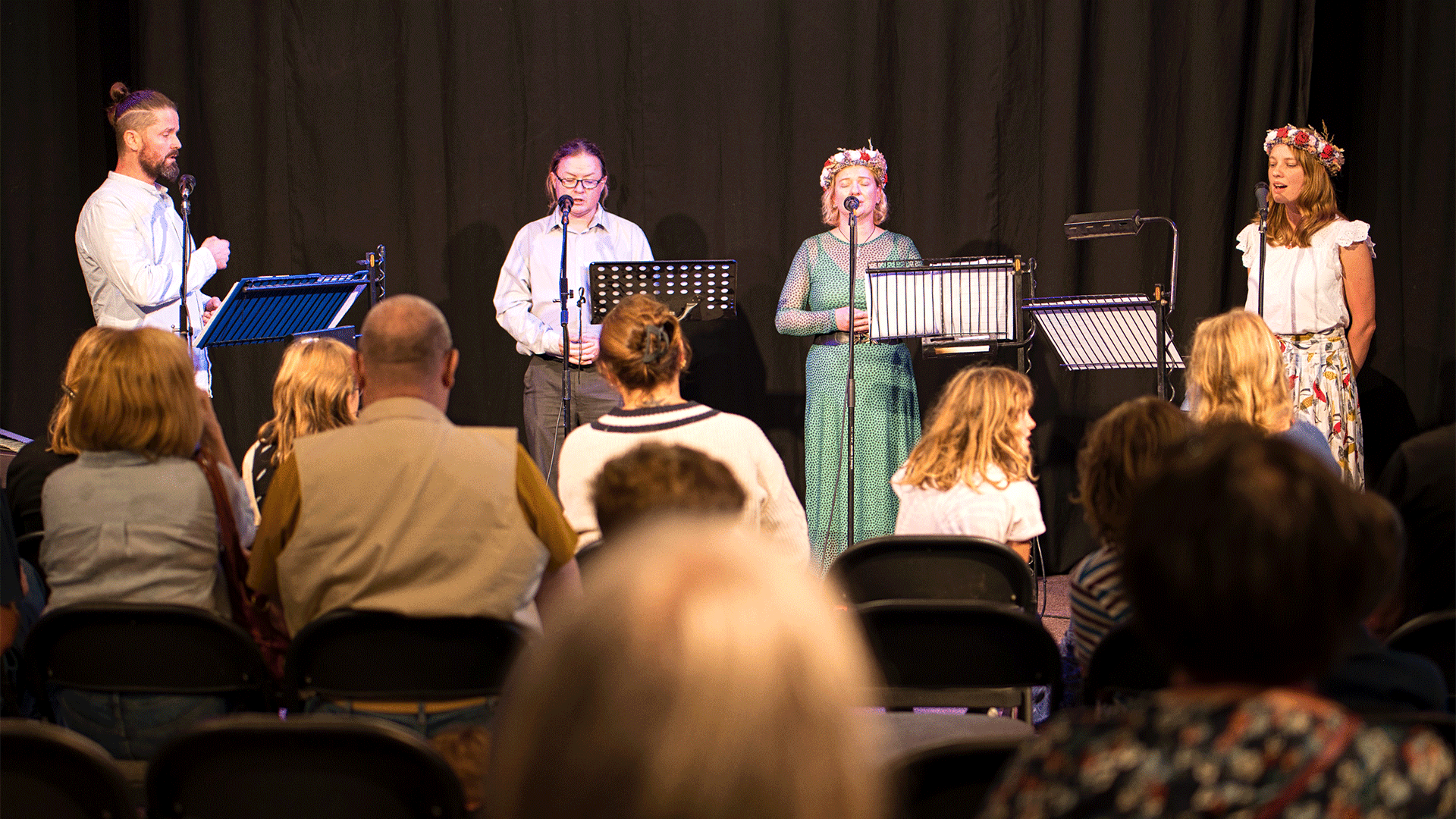 Four members of Polish choir TAK sing in front of an audience.