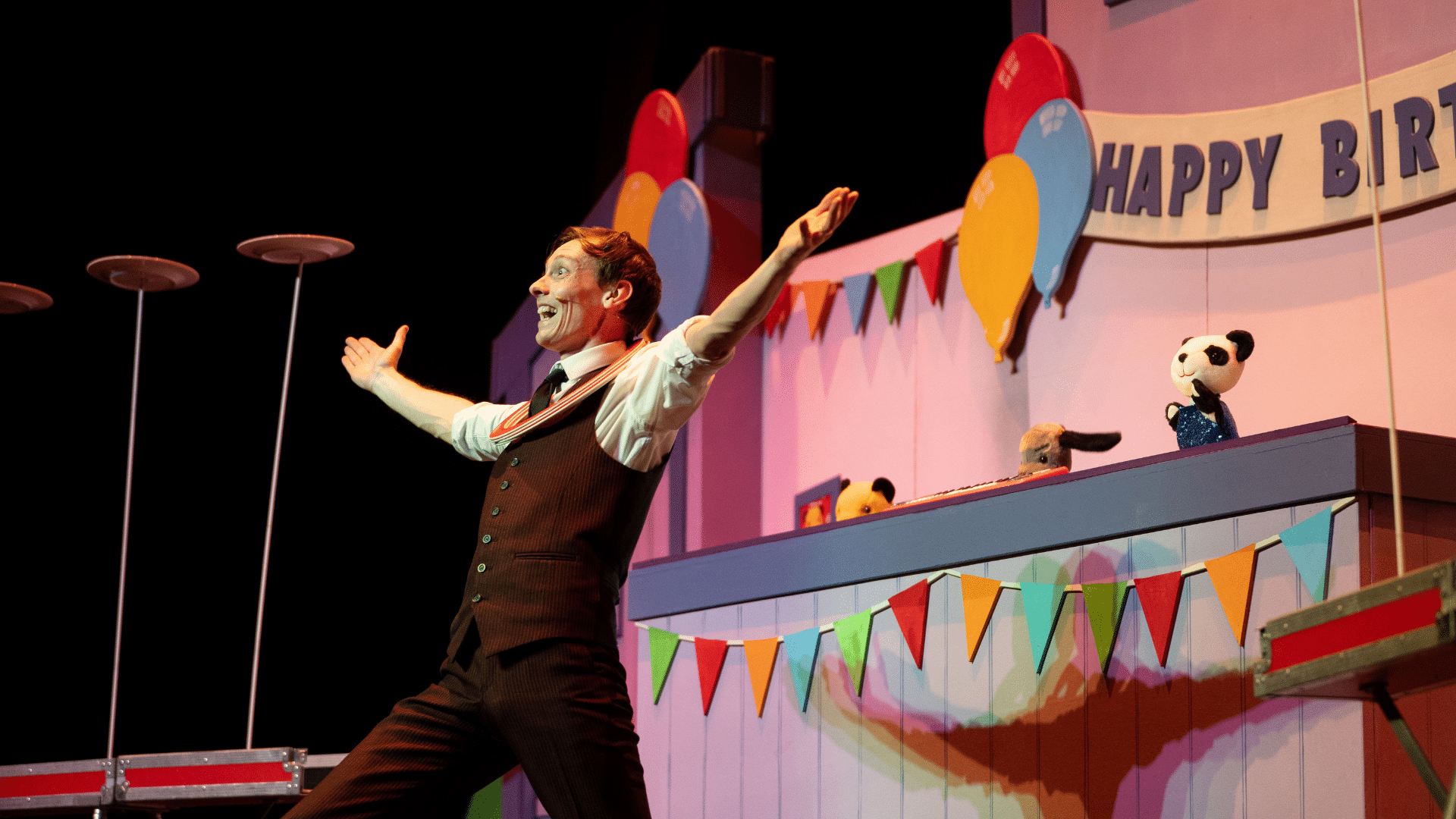 The Sooty Show production image: a man in a brown stripy suit holds his arms out and smiles at an off-camera audience.