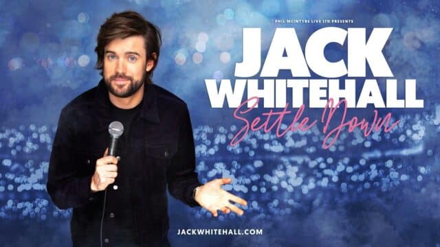 Jack Whitehall: Settle Down promotional artwork - Jack Whitehall, mic in hand, wearing a black denim jacket over a black t-shirt, facing forwards with a smile on his face and gesturing to the side with his left hand. Background is blue with lots of out of focus lights. White text reads: 'Phil McIntyre Live Ltd Presents Jack Whitehall'. Pink signature style text reads: 'Settle Down'. At the bottom, small white text reads: 'jackwhitehall.com'.