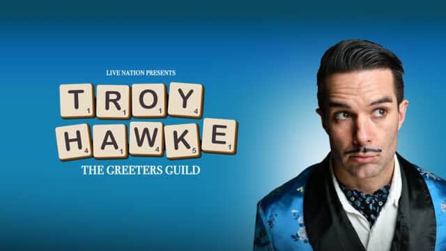 Troy Hawke: The Greeters Guild Promotional Artwork. Blue background. In white script, 'Live Nation Presents'; written with Scrabble letters 'Troy Hawke'; in white script, 'The Greeters Guild'. Right: a photo of Troy Hawke, with dark hair slicked back and a thin moustache drawn on with sharpie, wearing a blue satin suit and casting his eyes ponderously to his left.