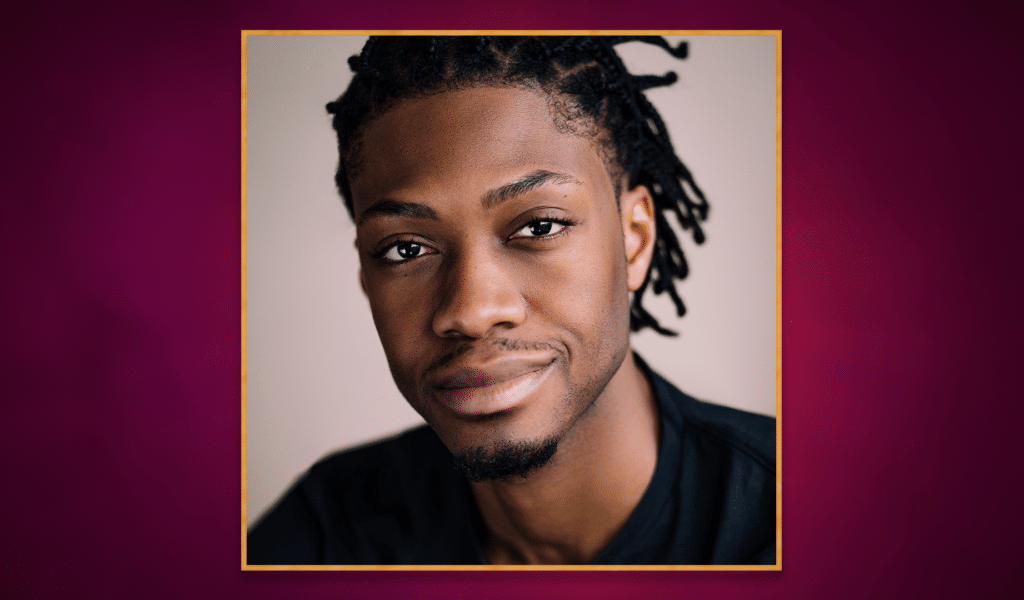Headshot photo of actor Andrew Dillon, a young black man with dark brown braided hair, wearing a black t-shirt. The headshot photo has a golden border around it, and is set on top of a purple gradient background.