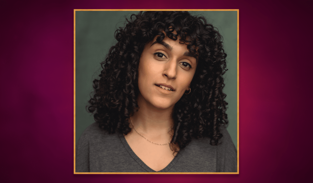Headshot photo of actor Sophia Lewis, a young black woman with dark brown curly hair, wearing grey sweater. The headshot photo has a golden border around it, and is set on top of a purple gradient background.