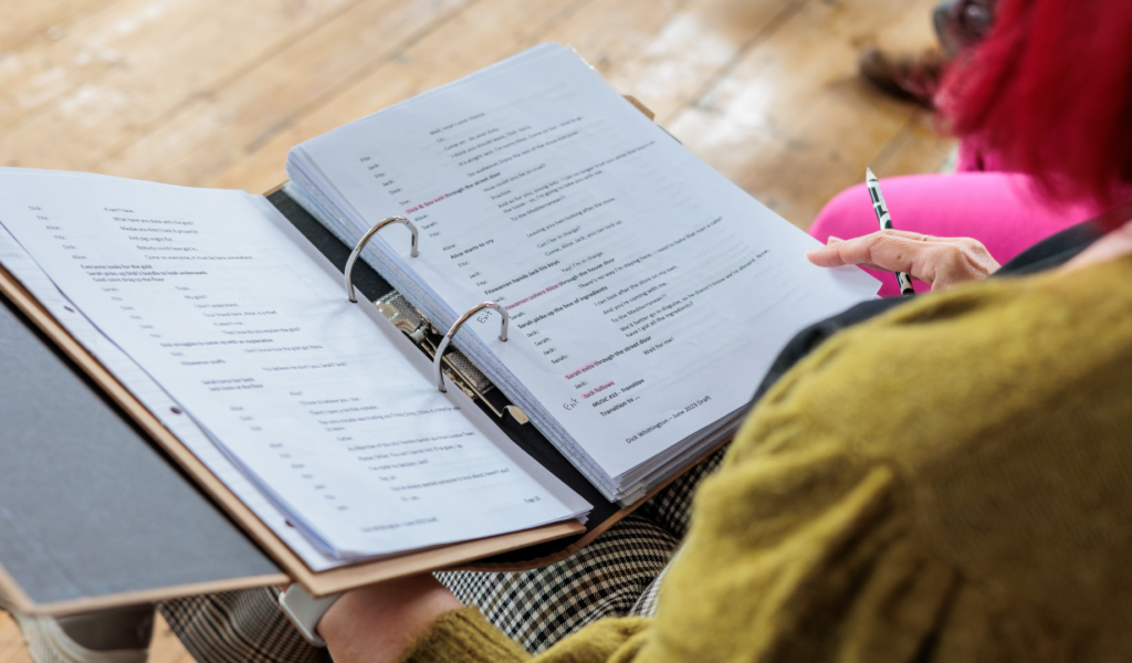 Looking over someone's shoulder at a play script.