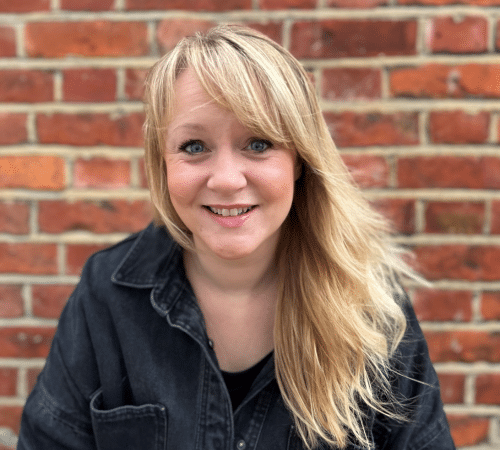 Headshot of Lauren King smiling against a brick wall.