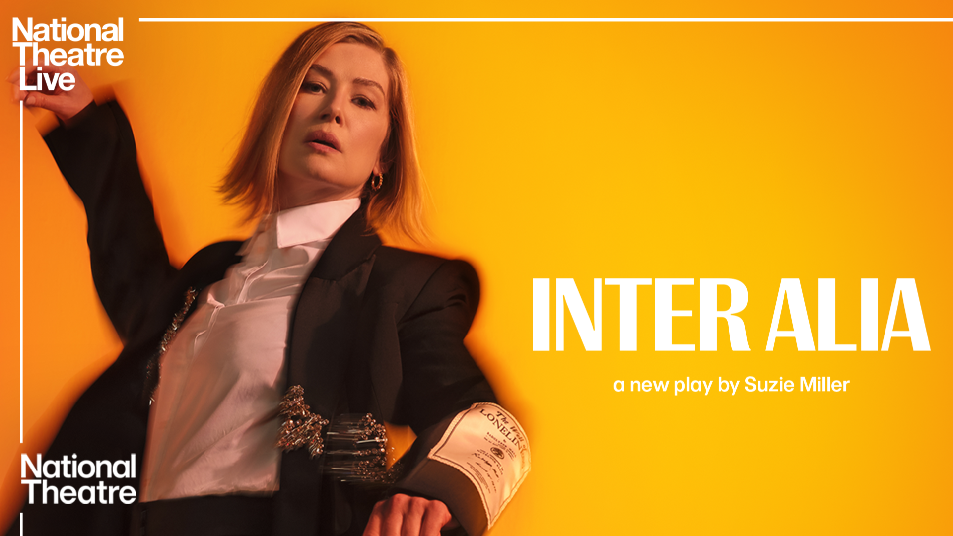 NT Live – Inter Alia promotional artwork: a photograph of Rosamund Pike wearing a suit and flailing her arms as though falling backwards. Text reads: 'National Theatre Live. Inter Alia. A new play by Suzie Miller. National Theatre'.