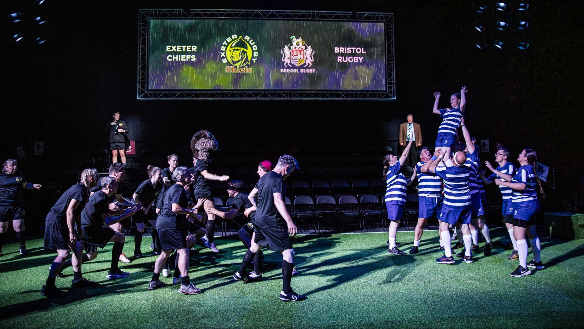 Two rugby teams face each other on stage. The Exeter Chiefs' opponents are performing a lift.