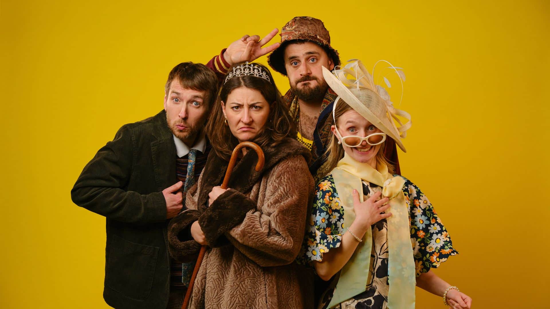 Madison Grace, Andrew Armfield, Jodie Micciché and Peter Watts pose in character against a yellow background.
