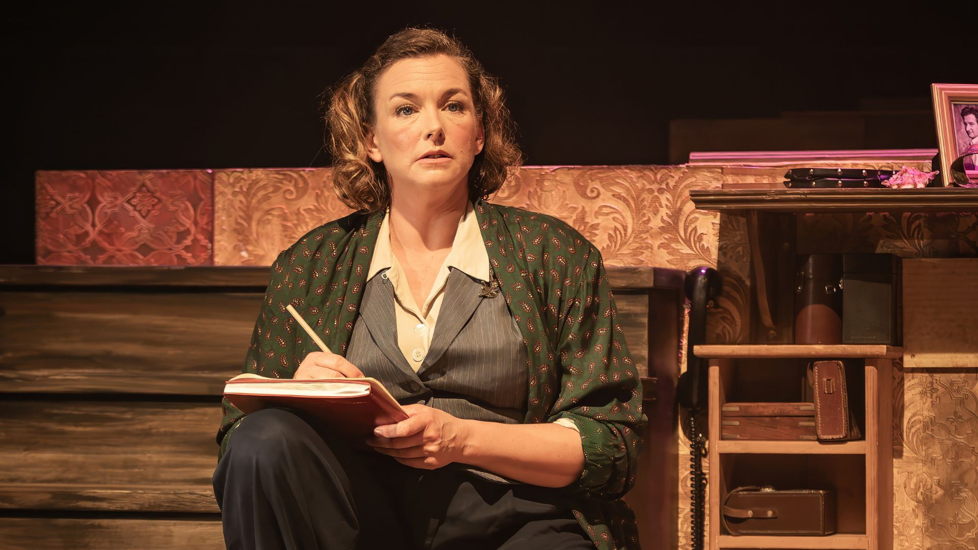 Emma Stansfield as Daphne Du Maurier sitting down writing in a notepad