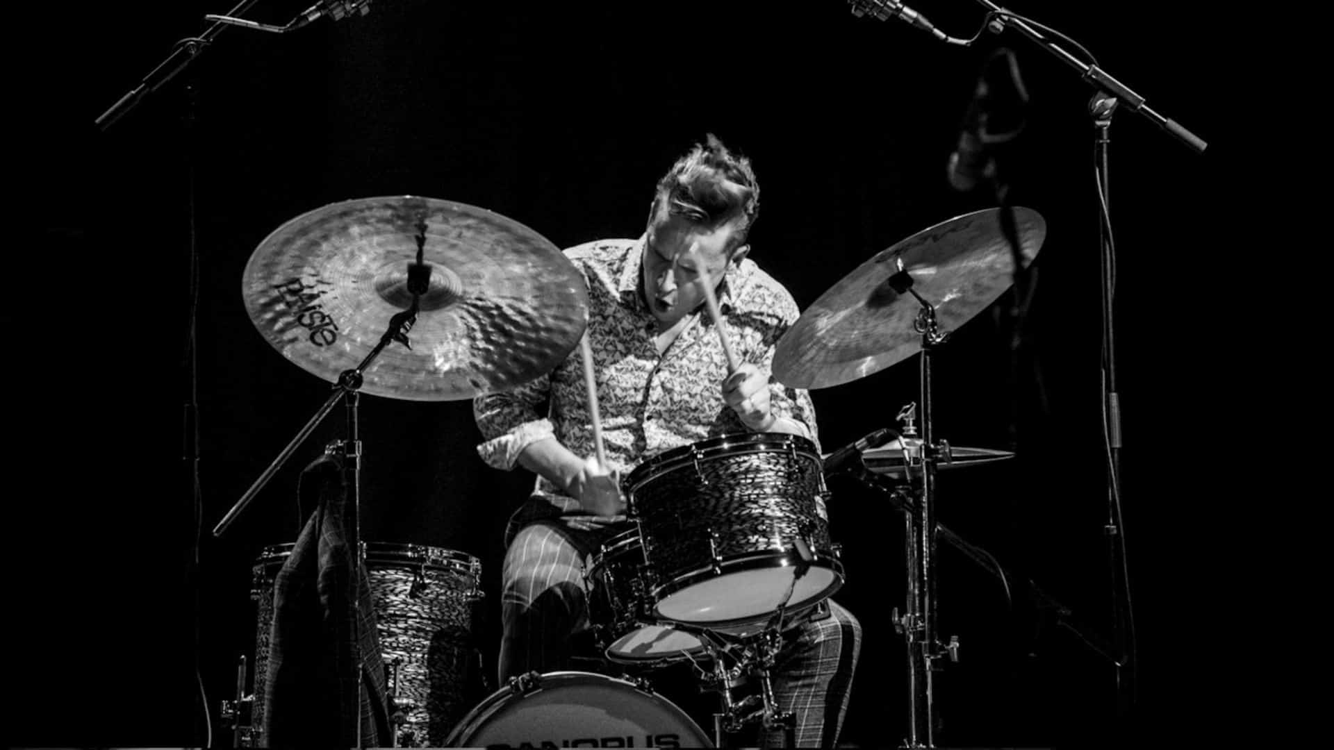 Image shows Ronnie Scott's Jazz Club drummer playing on stage.