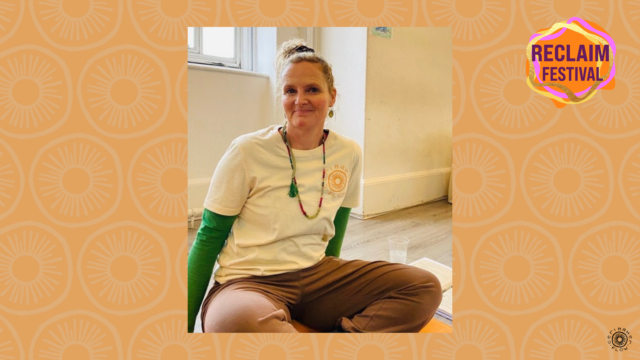 Photo of Ceri Baker sat cross-legged.