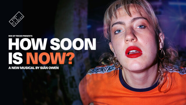 How Soon is Now promo artwork: Shows a blonde woman wearing a bright orange top and red lipstick she is staring directly at the camera. The text on the image reads Box of Tricks presents How Soon is Now. A new musical by Sian Owen