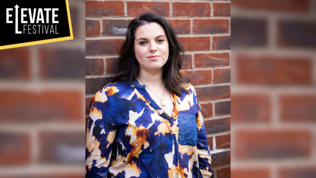 A photo of Anoushka Bonwick standing in front of a brick wall.
