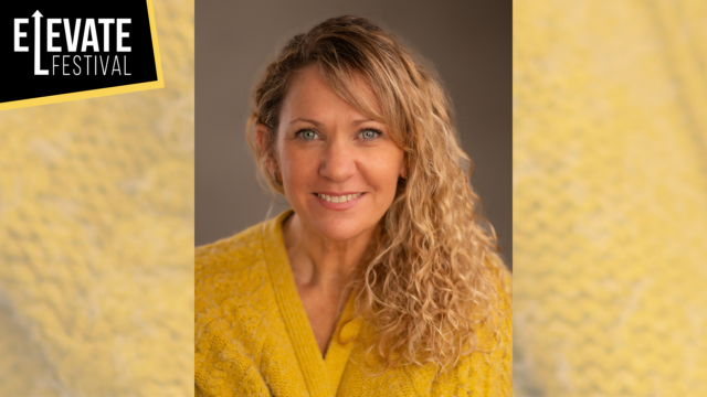 A photo of Sally K wearing a yellow cardigan smiling.