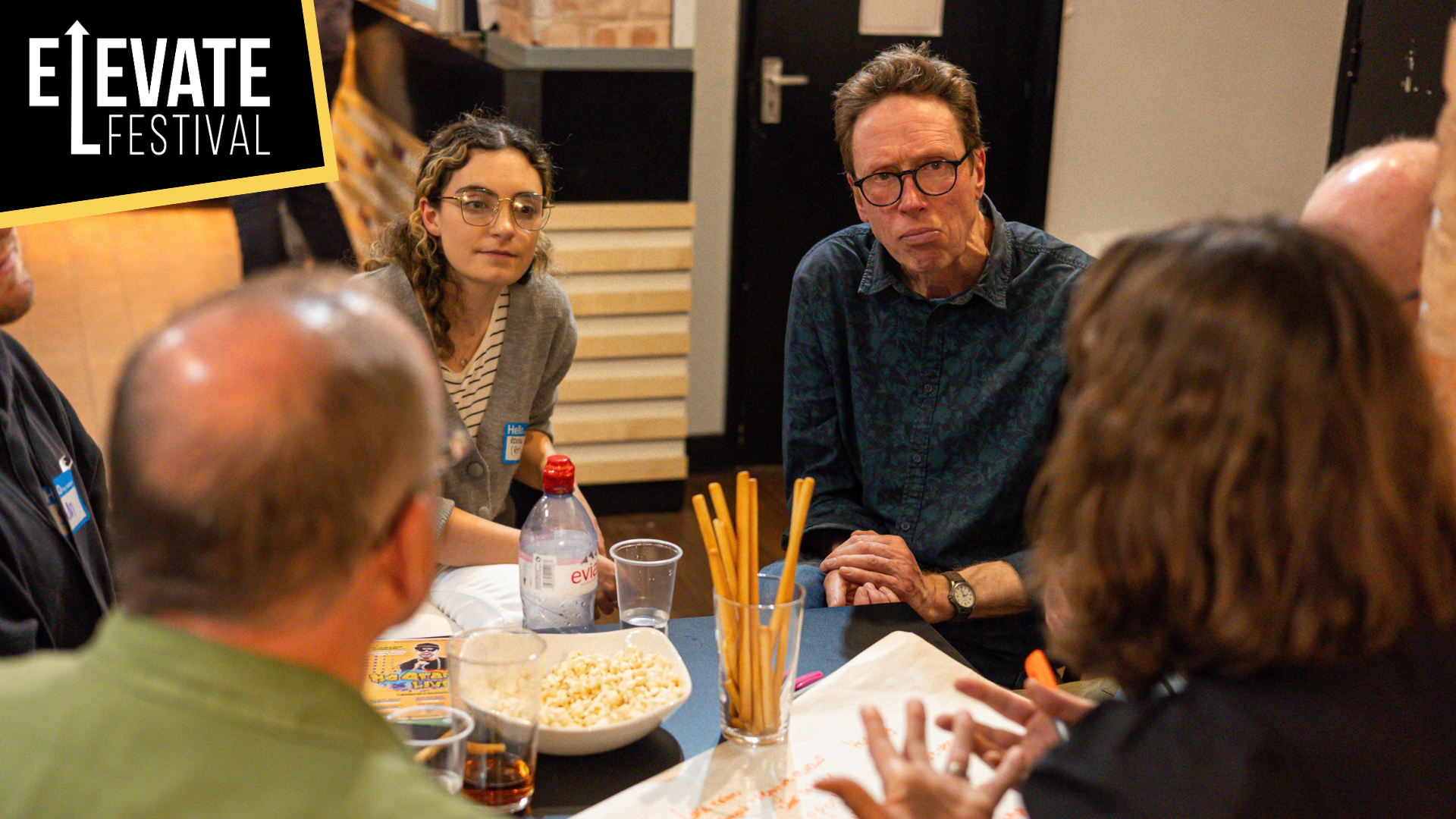 Image of artists sitting around a table having a discussion.